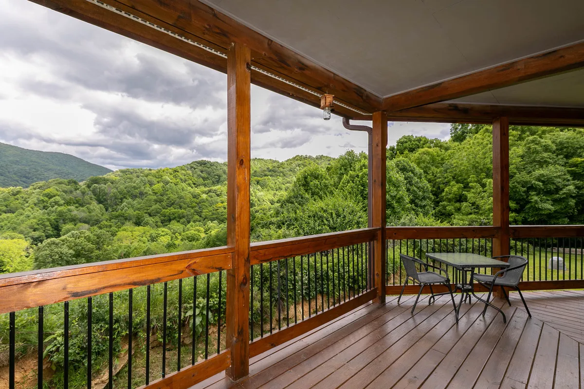 A serene outdoor seating area on a wooden deck featuring a table, chairs, and a beautiful mountain view beyond the railing. The setup suggests opportunities for enjoying meals al fresco, morning coffee, or quiet contemplation surrounded by nature. The image evokes the tranquility and inspiration that come from being immersed in the High Country environment.